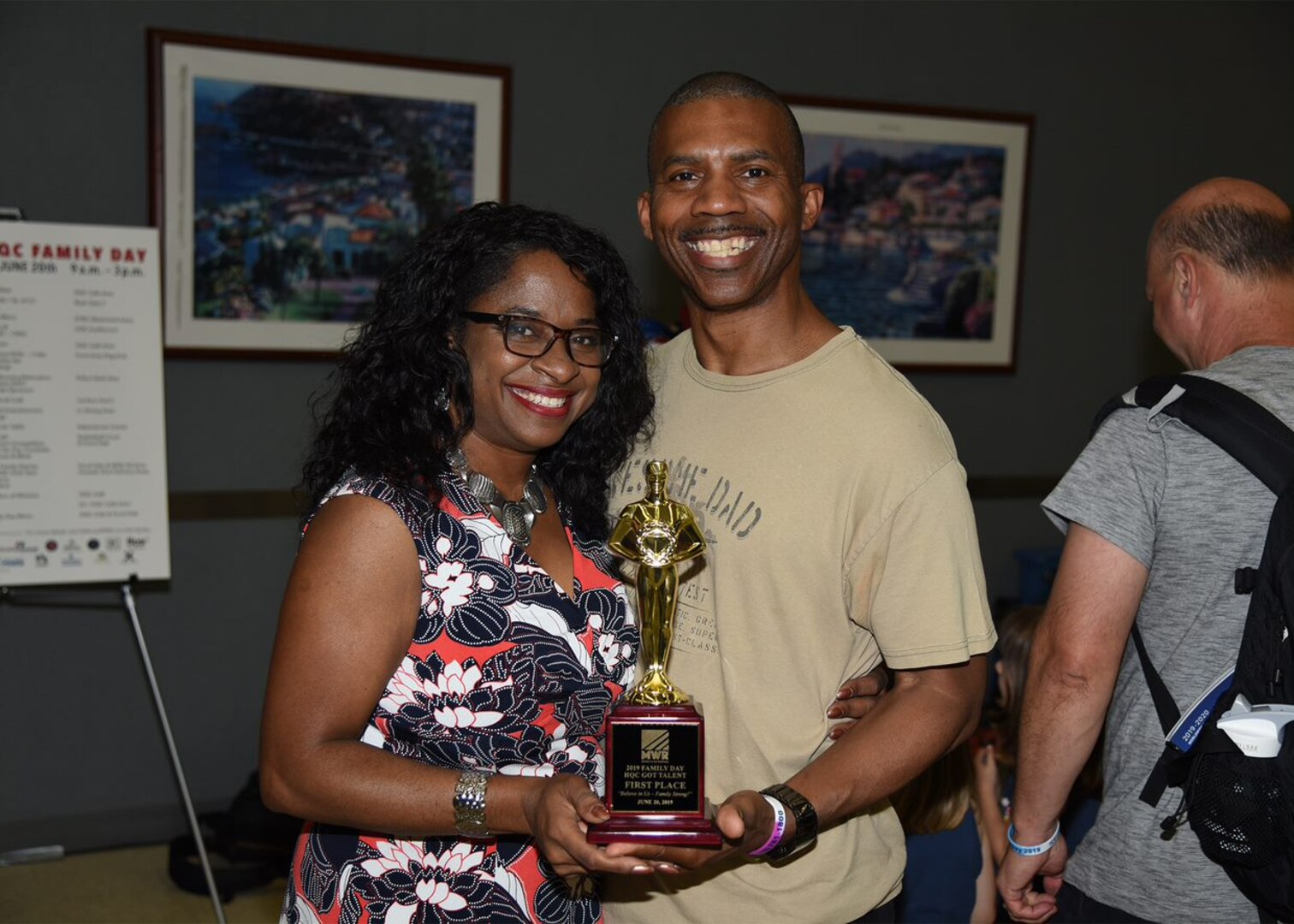 Woman and man holding a first-place trophy during HQC Family Day events.