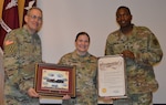 Brig. Gen. George Appenzeller (left), Brooke Army Medical Center commanding general, and Sgt. Maj. James Brown (right), chief clinical noncommissioned officer, present Army Capt. Ellen Simpson with the San Antonio Pride Month proclamation and a token of appreciation June 19 during the BAMC Pride Month observance. Simpson is a perioperative registered nurse at BAMC.