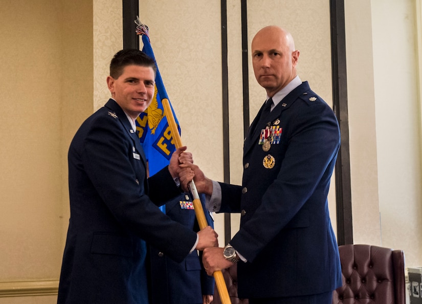 Col. Rockie Wilson, left, commander of the 628th Mission Support Group, passes the 628th Force Support Squadron guideon to Lt. Col. William Parker, right, outgoing commander of the 628th FSS, during a change of command ceremony at the Charleston Club June 21, 2019, Joint Base Charleston, S.C. The 628th FSS is responsible for deploying services and personnel support teams, quality of life, professional and personal readiness, manpower and personnel services, food operations, lodging, fitness and leisure activities. Parker will be assuming a new role as the 628th MSG deputy commander.