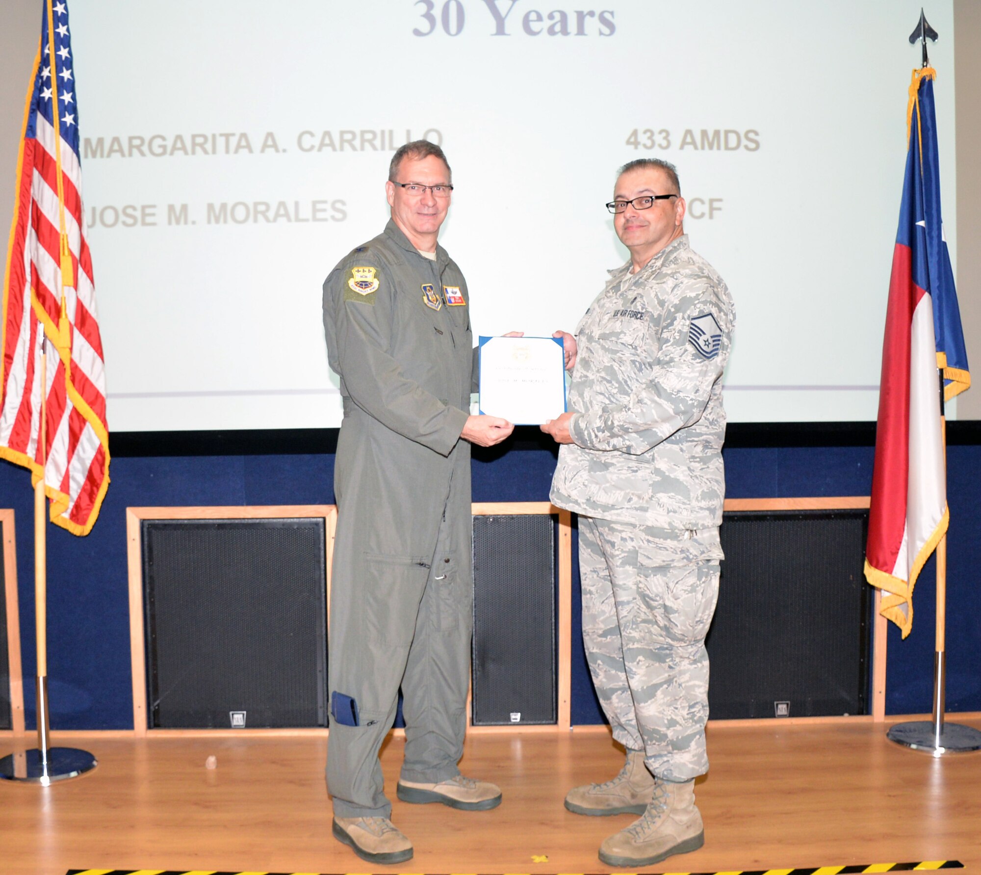 Col. Terry W. McClain, 433rd Airlift Wing commander, presents a 30-year service award certificate to Master Sgt. Jose M. Morales, 433rd Force Support Squadron Communications Element knowledge operations management supervisor, June 20, 2019 at Joint Base San Antonio-Lackland, Texas.