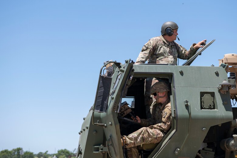 Two U.S. Army National Guard Soldiers look out of a High Mobility Rocket System.