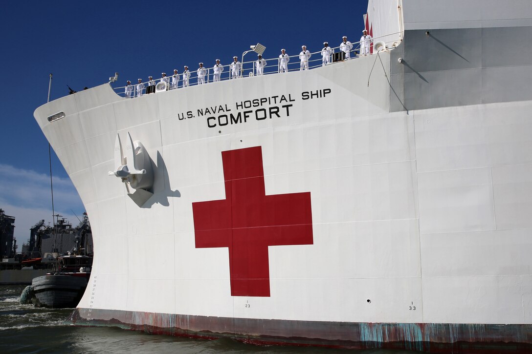 Sailors man the rails as the USNS Comfort pulls away from pier.