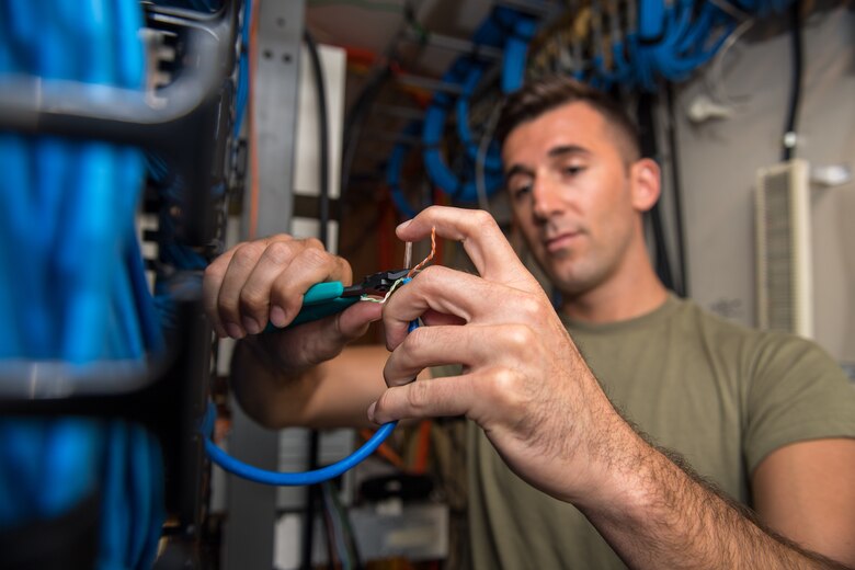 U.S. Air Force Tech. Sgt. Kenneth Overstreet, 178th Communications Squadron client systems from the Ohio Air National Guard, prepares a cable for connection at Tyndall Air Force Base, Florida, June 18, 2019.