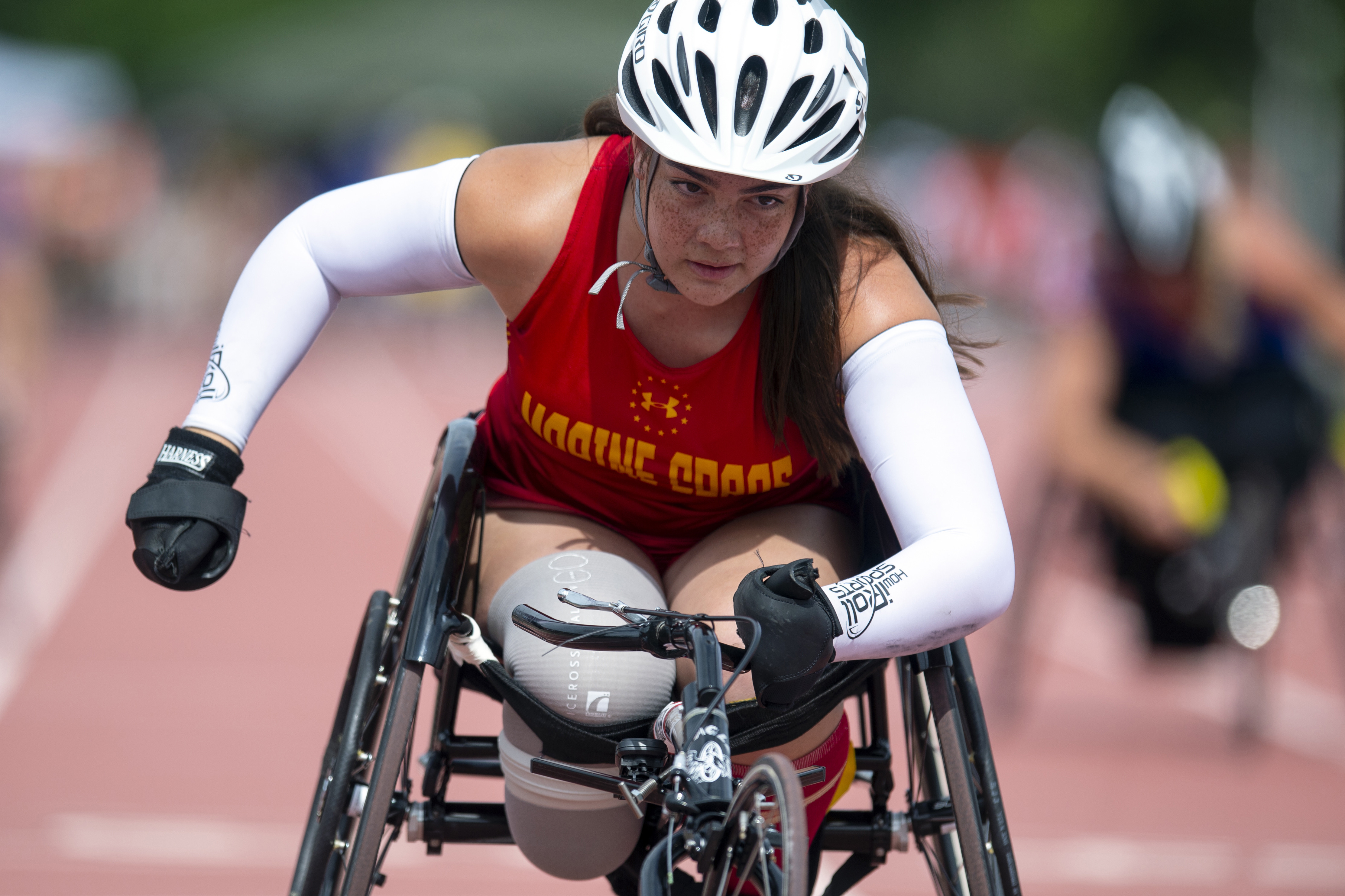 A female wheelchair racers drives towards the finish line during the 2019 Warrior Games.