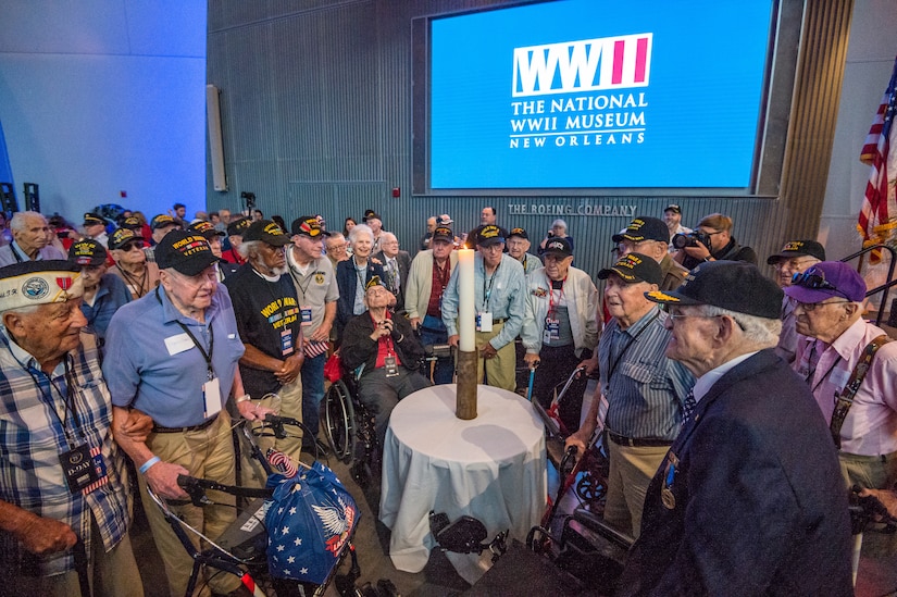 WWII veterans assemble around the Light of Remembrance candle at the National WWII Museum in New Orleans, La. on June 6, 2019.