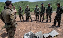 Explosive ordnance disposal technicians assigned to U.S. Navy Explosive Ordnance Disposal Mobile Unit (EODMU) 5 and the Royal Thai Navy Diver and Explosive Ordnance Disposal Center discuss the effects of an improvised demolition charge device during a controlled, live-fire demolition knowledge exchange as part of Cooperation Afloat Readiness and Training (CARAT) Thailand 2019. (U.S. Navy photo by Mass Communication Specialist 2nd Class Kelsey L. Adams)