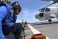 Ship's Serviceman 3rd Class Christopher Camacho, from Hesperia, Calif. observes a Royal Thai Navy S-70B helicopter preparing to launch from the flight deck of the Ticonderoga-class guided-missile cruiser USS Antietam (CG 54) during Cooperation Afloat Readiness and Training (CARAT) Thailand 2019. (U.S. Navy photo by Mass Communication Specialist 1st Class Toni Burton)