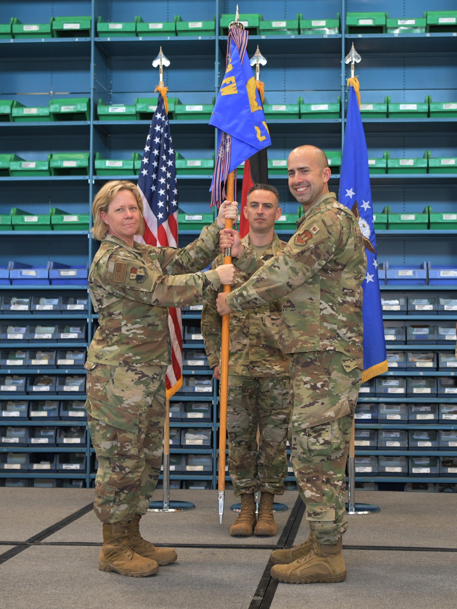 U.S. Air Force Col. Marlyce Roth, 52nd Mission Support Group commander, left, passes the ceremonial guidon to Maj. Juan Fiol, incoming 52nd Logistics Readiness Squadron commander, right, during the 52nd LRS change of command ceremony at Spangdahlem Air Base, Germany, June 24, 2019. (U.S. Air Force photo by Airman 1st Class Jovante Johnson)