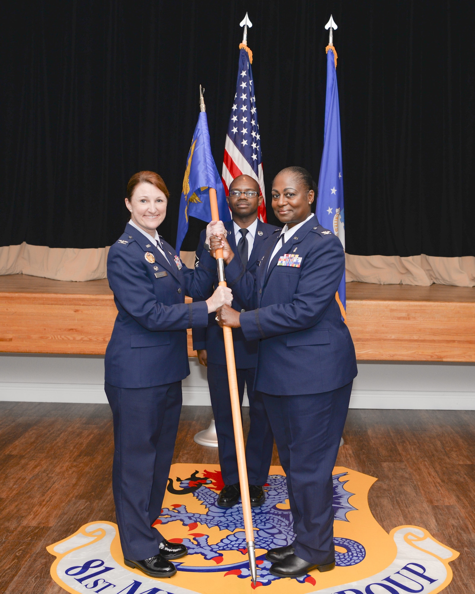 U.S. Air Force Col. Beatrice Dolihite, 81st Medical Group commander, gives the 81st Inpatient Operations Squadron guidon to Col. Mary Parker, incoming 81st IPTS commander, during the 81st IPTS change of command ceremony inside the Don Wylie Auditorium on Keesler Air Force Base, Mississippi, June 21, 2019.
