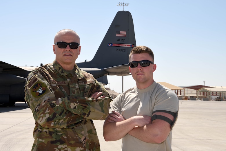 Mgt. Donald McCormick, 379th Expeditionary Operation Support Squadron C-130 aircrew flight equipment section NCOIC and Staff Sgt. Dillon McCormick, 379th Expeditionary Aircraft Maintenance Squadron aircraft electrician take a photo together at Al Udeid Air Base, Qatar on June 21, 2019. For the father and son duo, the experience of serving together has been very positive especially while being deployed. (U.S. Air Force photo by Staff Sgt. Ashley L. Gardner)