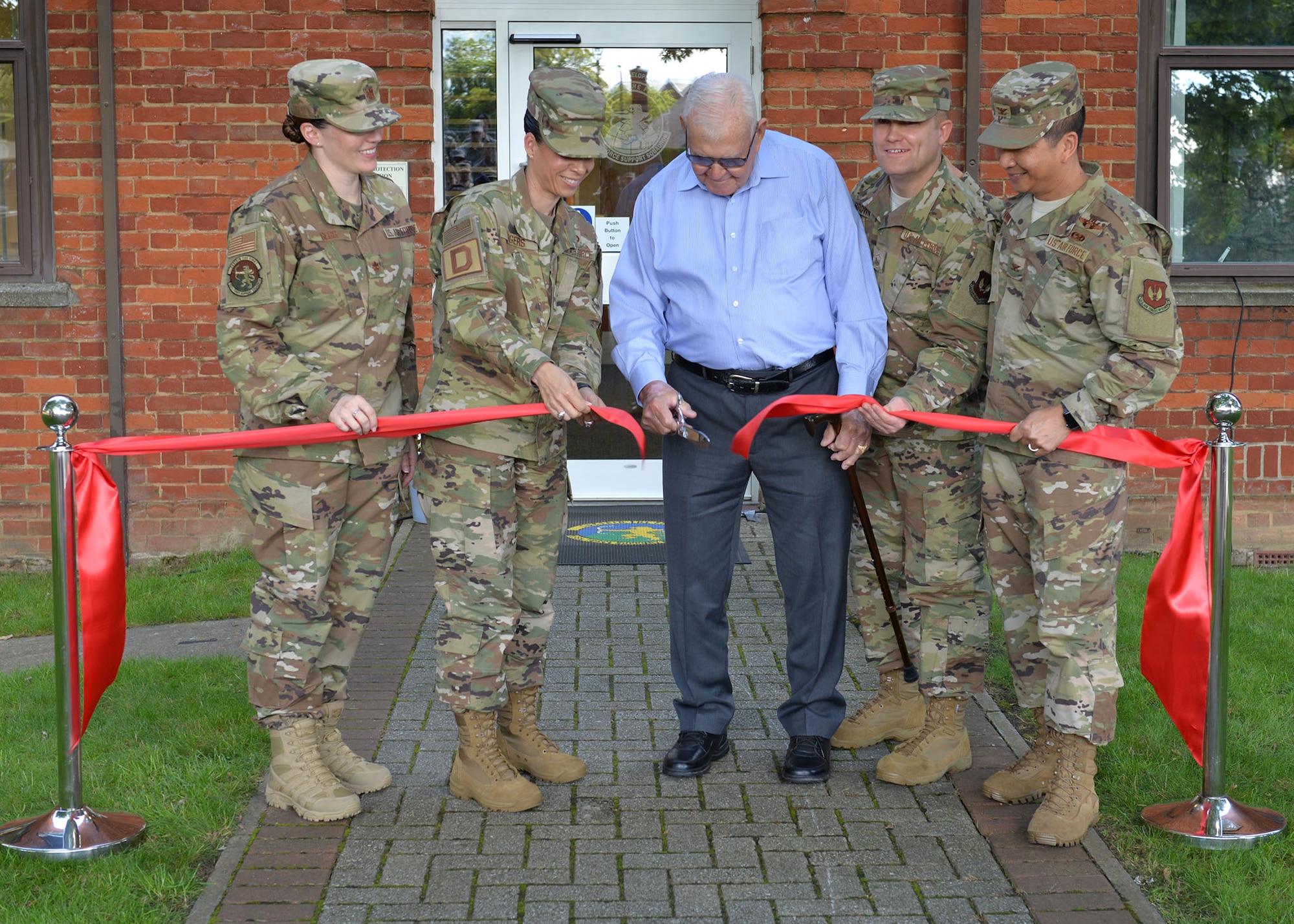 Retired Master Sgt. Dewey Christopher, center, a former 351st Bomb Squadron crew chief, 100th Bomb Group and World War II veteran, stands with 100th Air Refueling Wing leadership as he cuts the ribbon at the Professional Development Center renaming ceremony on RAF Mildenhall, June 21, 2019. The PDC was renamed the “Dewey R. Christopher Professional Development Center” to honor his legacy and enhance heritage for enlisted members. (U.S. Air Force photo by Karen Abeyasekere)