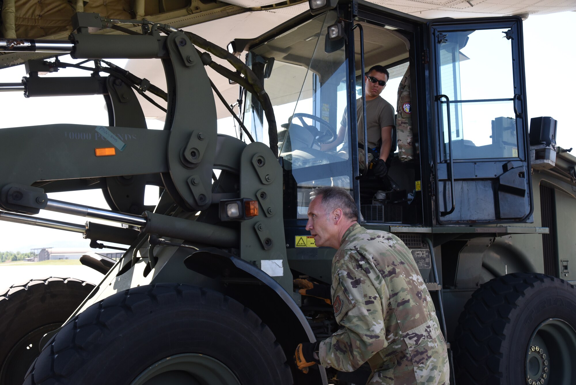 Master Sgt. Douglas Otten Jr, loadmaster for the 815th Airlift Squadron from the 403rd Wing, directs Senior Airman Daniel Morales, 26th Aerial Port Squadron, Lackland Air Force Base, Texas, who was driving a forklift to load a cargo pallet onto a C-130J for exercise Swift Response 19, June 19, 2019. The exercise is one of the premier military crisis response training events featuring high readiness airborne forces from eight NATO nations. Activities include intermediate staging base operations, multiple airborne operations, and several air assault operations. The Swift Response exercises have had great success in creating a foundation for the strong relationships we share with several European allies and partners today. (U.S. Air Force photo by Master Sgt. Jessica Kendziorek)