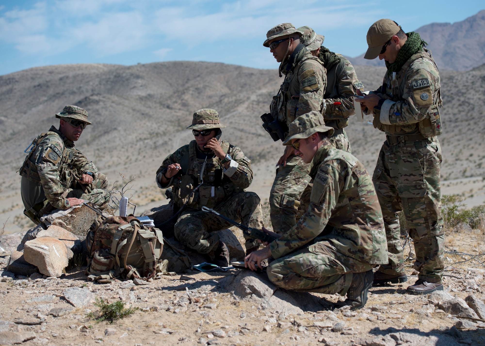 Capt. Robert Steiner, a tactical air control party specialist assigned to the 124th Air Support Operations Squadron, Idaho Air National Guard, assists the Brazilian Air Force TACPs  at the National Training Center, Fort Irwin, California, June 12, 2019. The Brazilian Air Force was training with the 124 ASOS TACPs and the 12th Combat Training Squadron TACPS during NTC. (U.S. Air National Guard photo by Senior Airman Mercedee Wilds)