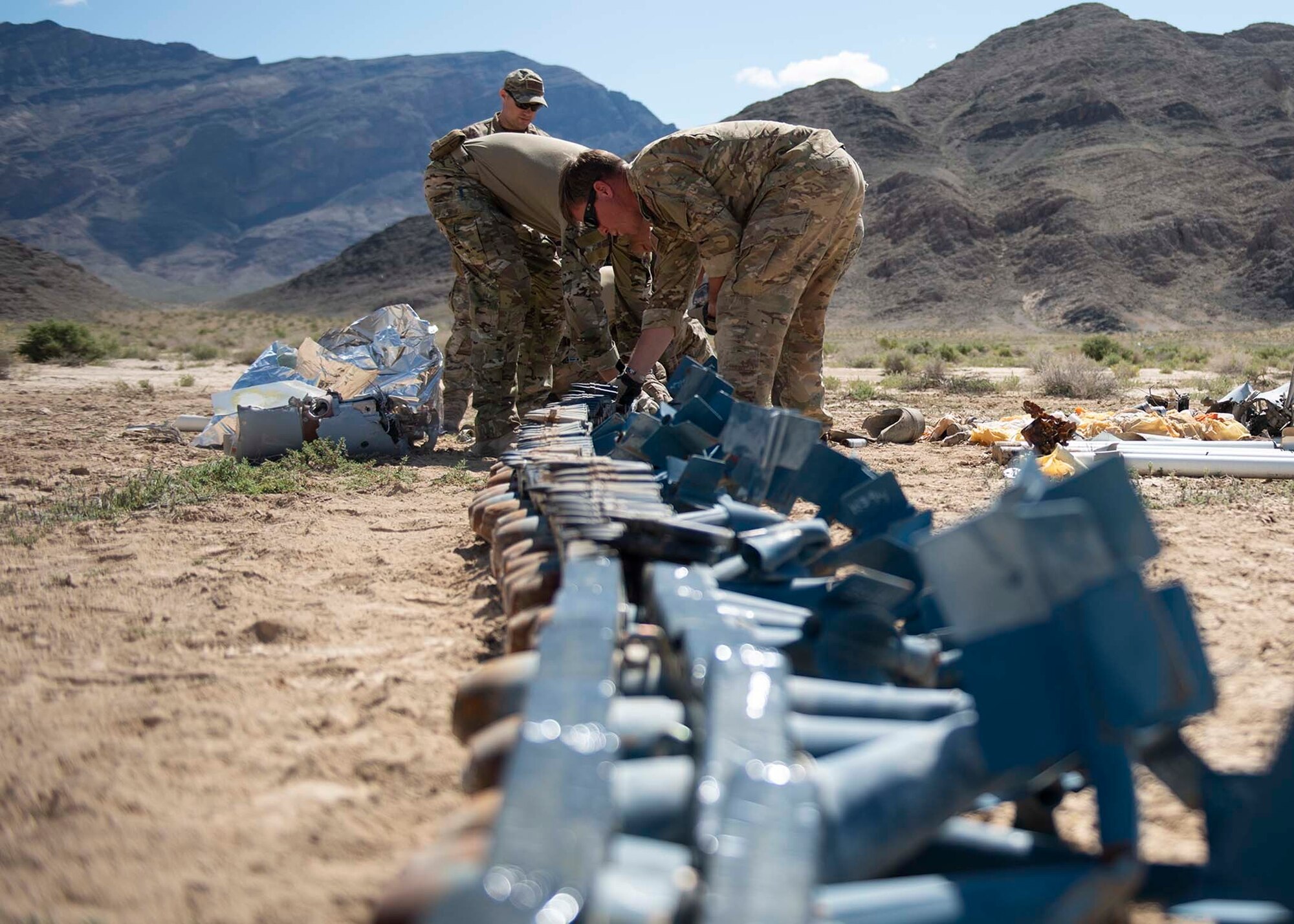 Explosive Ordnance Disposal technicians lay unexploded ordnance on the ground.