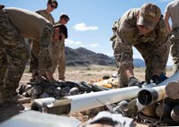 Explosive Ordnance Disposal technicians lay unexploded ordnance on the ground.