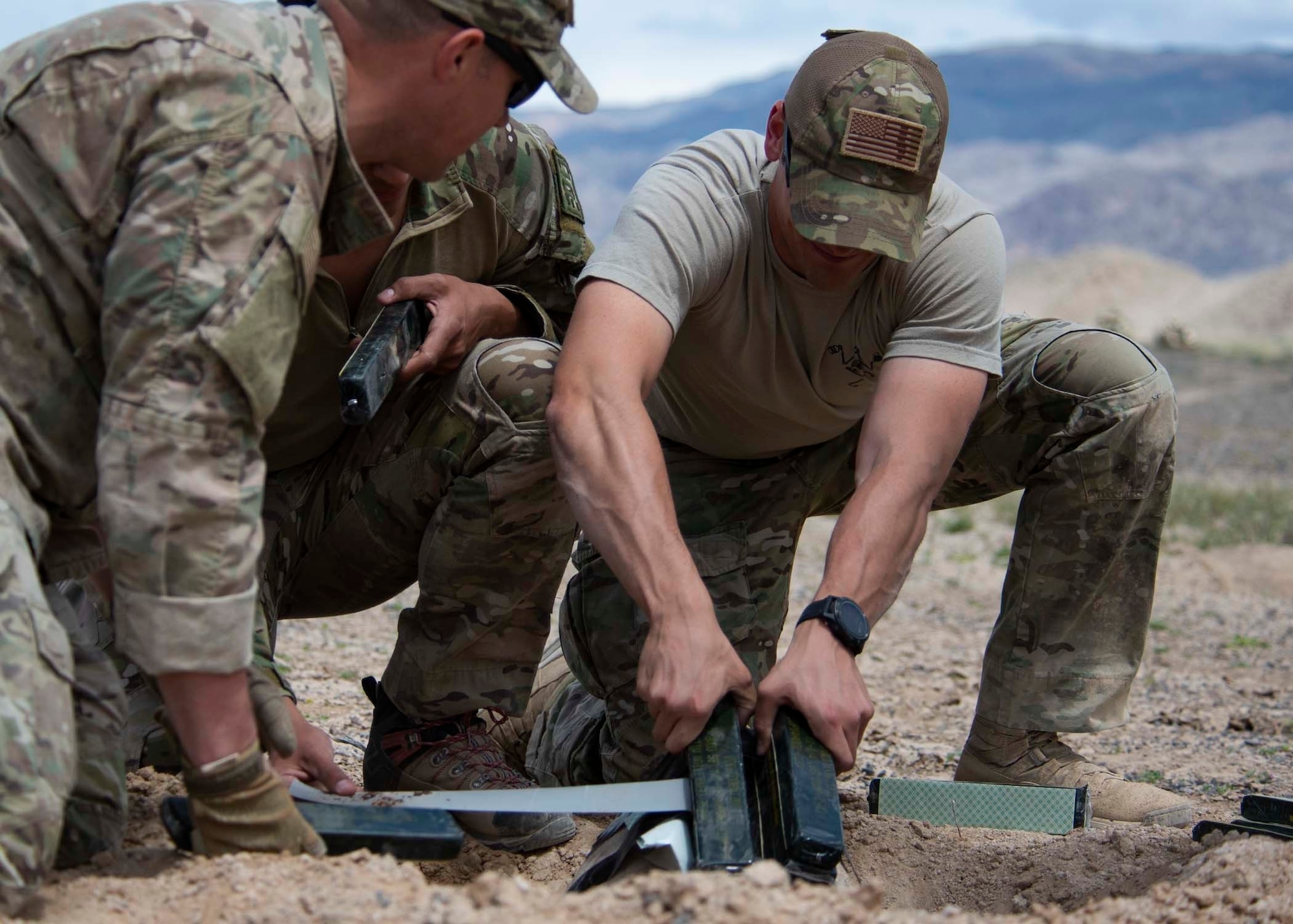 Explosive Ordnance Disposal technicians lay down explosives on to an unexploded ordinance.