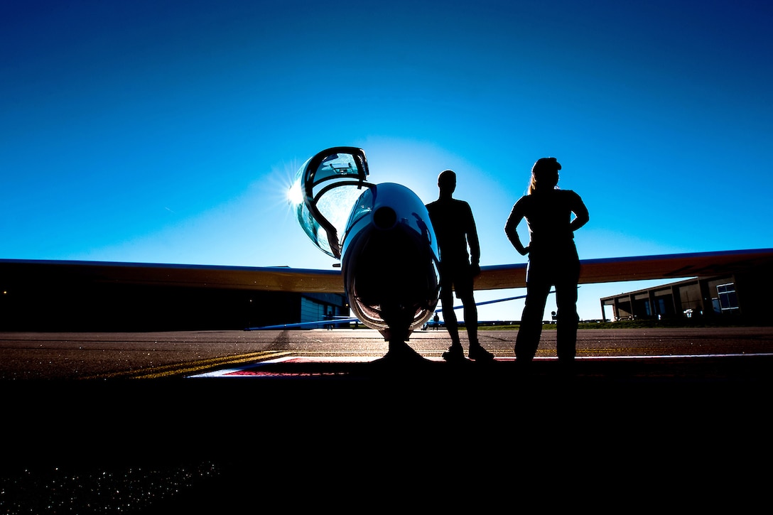 Air Force cadets stand next to a sailplane.