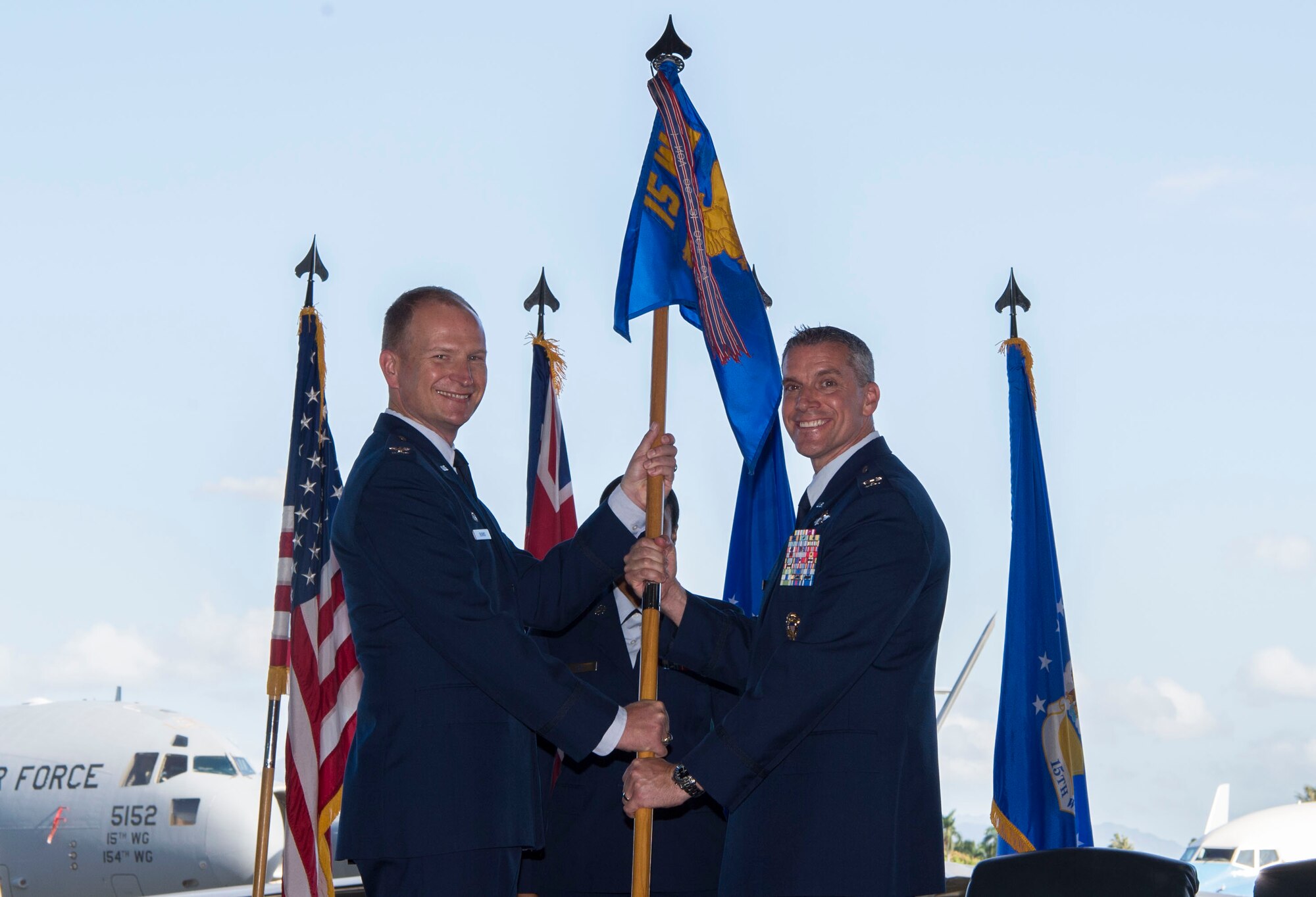 Col. Halsey Burks, 15th Wing commander, hands the squadron flag to Lt. Col. Scott Berndt, 15th Operations Group commander, during the 15th Operations Group Assumption of Command Ceremony, at Joint Base Pearl Harbor-Hickam, Hawaii, June 18, 2019. The 15th OG oversees operations at the largest joint-use airflield in the U.S., executes global combat and peace time operations, and provides executive airlift for senior military leaders. (U.S. Air Force photo by Tech. Sgt. Heather Redman)