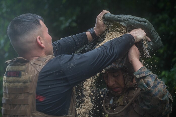 U.S. Marine Corps Marital Arts Program Instructor Trainer Staff Sgt. Cesar Menendezezlozano, left, awards Cpl. Abimael Reyes-Aguilar, right, his Marine Corps Martial Arts Program Instructor tab at Camp Hansen, Okinawa, Japan, June 20, 2019. Menendezezlozano, a manpower chief with Combat Logistics Regiment 35, 3rd Marine Logistics Group, held the instructor course to create MCMAP force multipliers not only for the MLG but for the entire III Marine Expeditionary Force. Menendezezlozano is a native of Chicago, Illinois. Reyes-Aguilar, a food service specialist with Food Service Company, Combat Logistics Regiment 37, 3rd MLG, is a native of Gardena, California. (U.S. Marine Corps photo by Lance Cpl. Isaiah Campbell)
