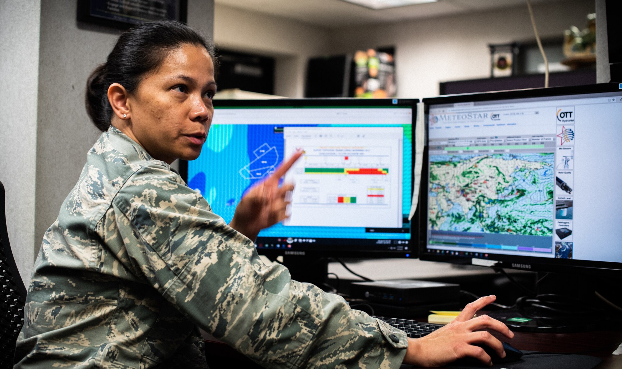 U.S. Air Force Capt. Richelle Greer, 18th Operations Support Squadron weather flight commander, monitors tropical cyclone conditions of readiness.