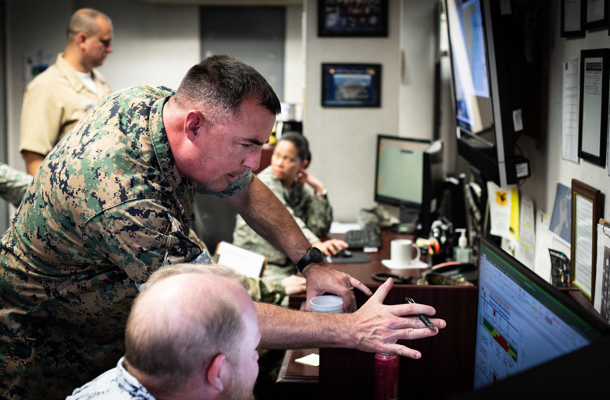 U.S. Marine Corps Capt. George Mills, senior weather officer, III Marine Expeditionary Force Weather, works alongside sister-service members.