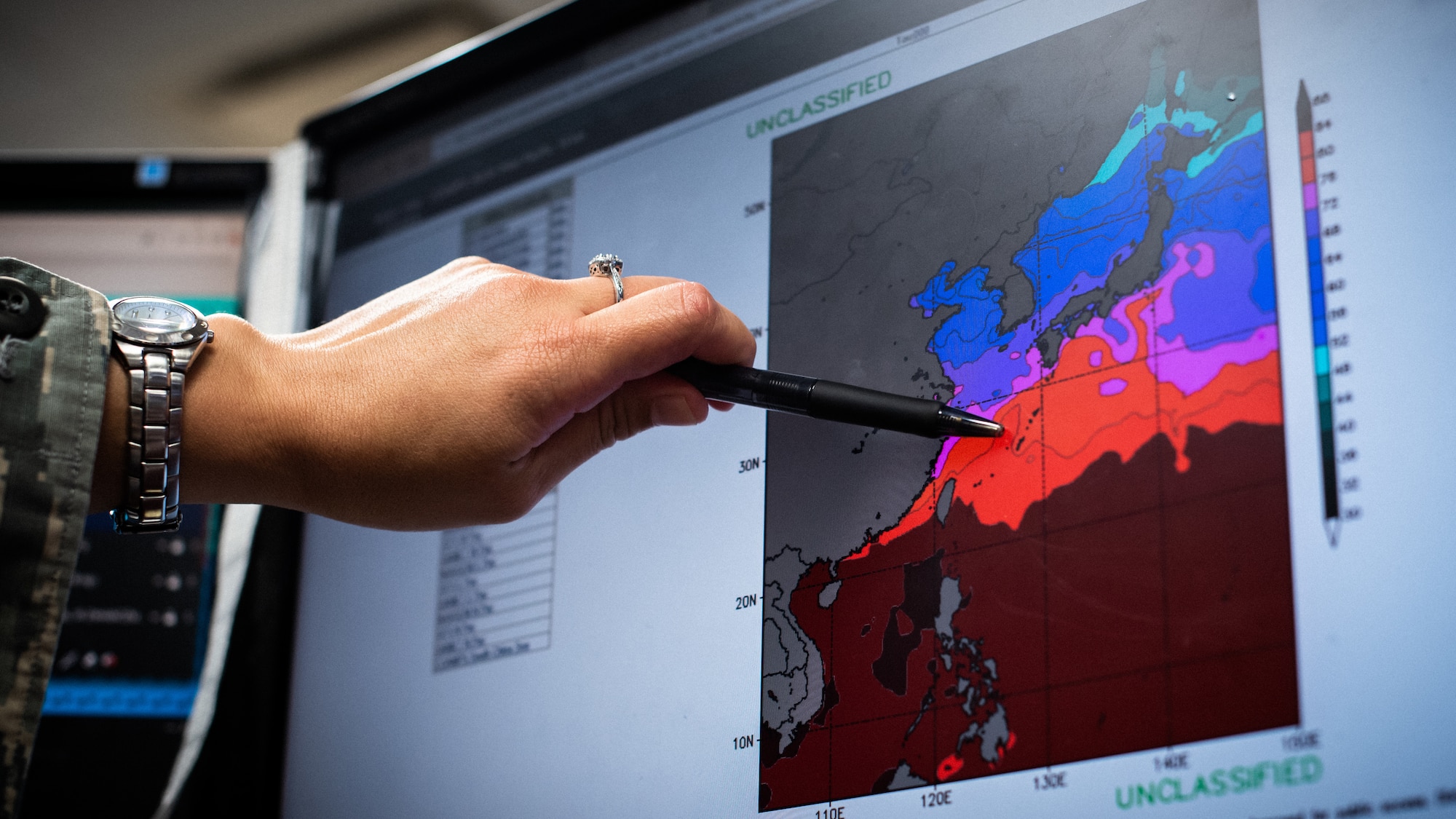 U.S. Air Force Capt. Richelle Greer, 18th Operations Support Squadron weather flight commander, points out the tropical cyclone conditions of readiness.