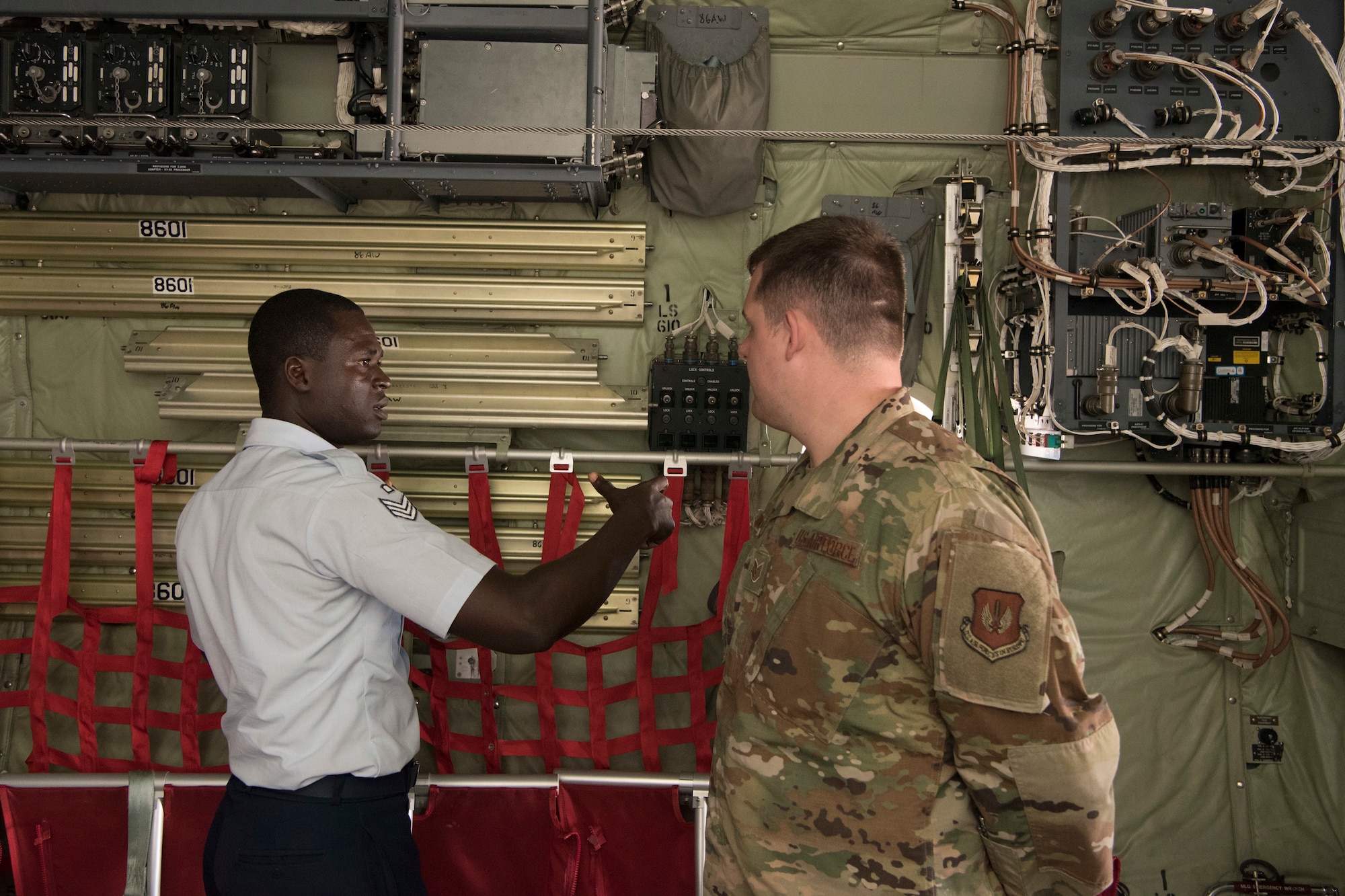 A U.S. Air Force Team Ramstein airman listens to a Ghana air force delegate as he compares the differences of the interior appearance of Ghana aircraft versus the C-130J Super Hercules he stood in on Ramstein Air Base, Germany, June 19, 2019. Over 40 air force delegates from eight different nations toured the C-130J Super Hercules as part of the African-European Partnership Flight event. (U.S. Air Force photo by Senior Airman Kristof J. Rixmann)