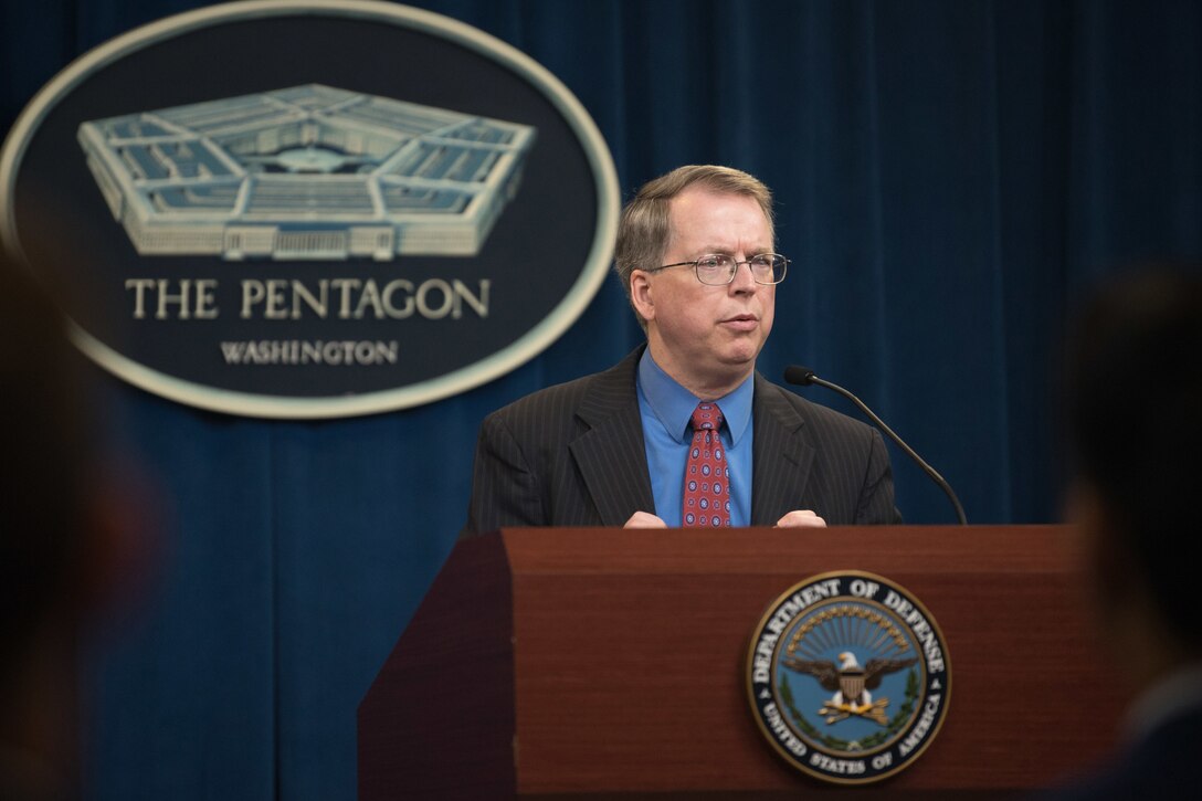 A man speaks from behind a podium.