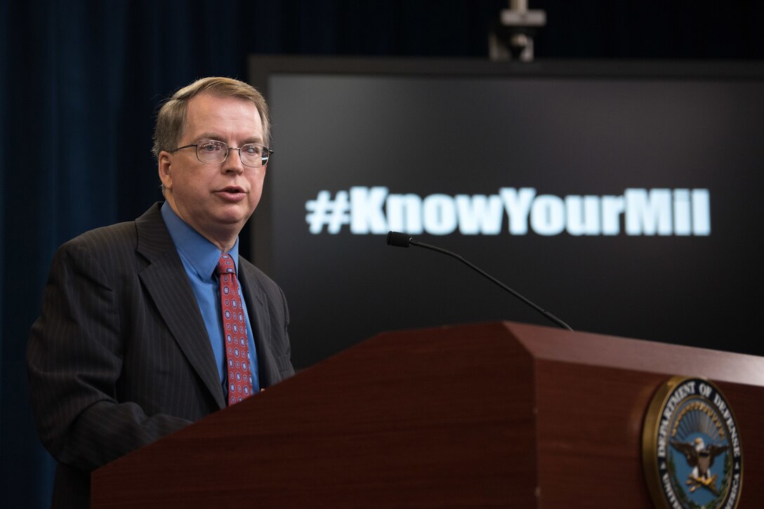 A man speaks from behind a podium.