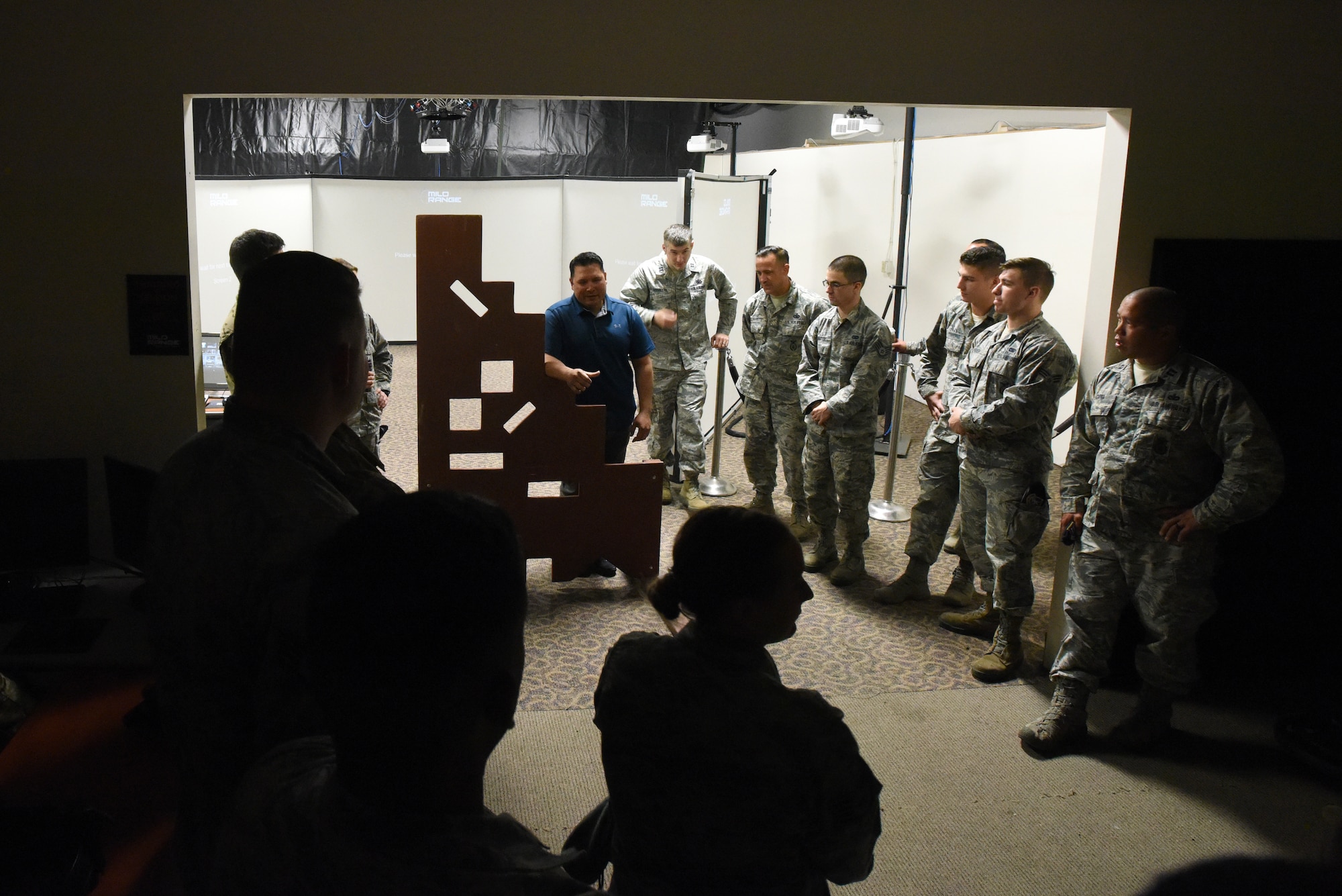 U.S. Air Force Master Sgt. Kaleo Vincente (center), 176th Security Forces Squadron (SFS) unit trainer gives directions to members of the North Carolina (NC) and Louisiana (LA) Air National Guard (ANG) as they prepare to conduct use of force and tactical situational practice in a Fire Arms Training Simulator simulator June 12, 2019 at the 176th SFS in Anchorage, AK. The 145th Security Forces and 263rd Combat Communications Squadrons with the NCANG, and the 159th Security Forces Squadron with the LANG travel to Joint Base Elmendorf-Richardson to train on various tactical and strategic law enforcement procedures during annual training.