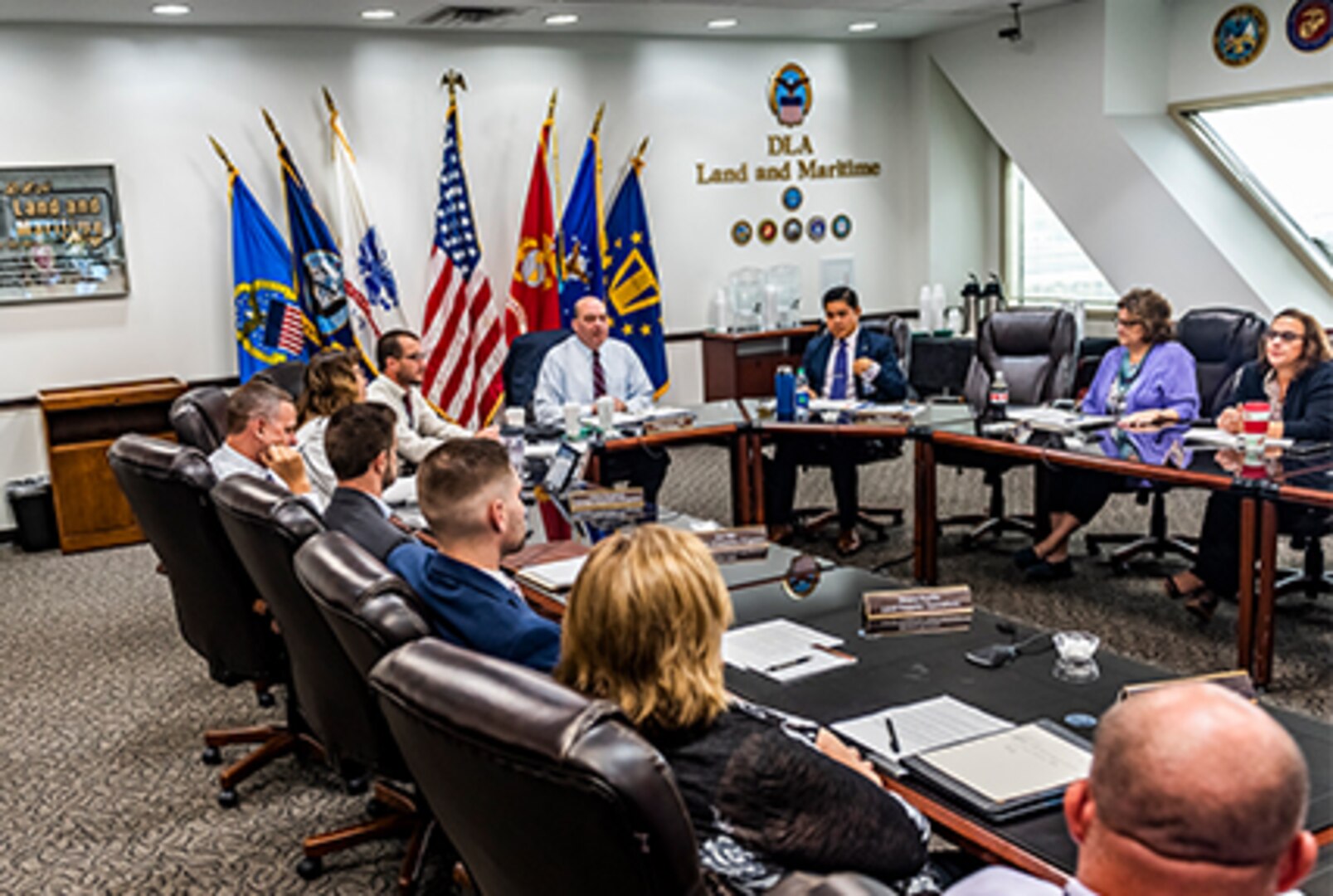 People siting at u-shaped table in meeting