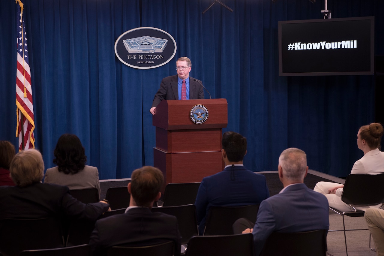 A man speaks from behind a podium.