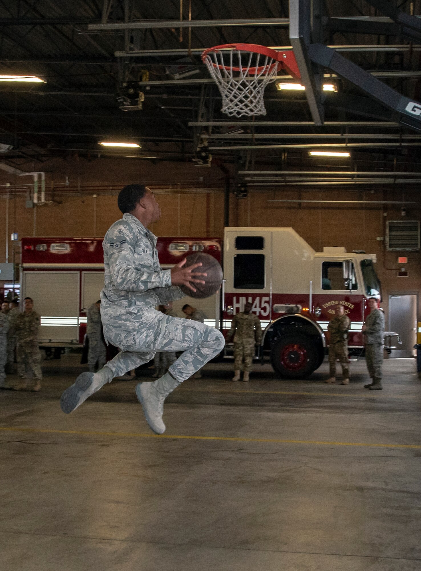 U.S. Air Force Airman Rex Miles and Airman 1st Class Cody Shelton, 60th Civil Engineer Squadron electrical system technicians, play basketball June 24, 2019, at Travis Air Force Base, California. The Airmen engaged in an impromptu basketball game prior to a squadron group photo. The Air Force Fitness Program’s goal is to motivate Airmen to participate in a year-round physical conditioning program that emphasizes total fitness, including proper aerobic conditioning, strength and flexibility training and healthy eating. Health benefits from an active lifestyle increases productivity, optimizes health and decreases absenteeism while maintaining a higher level of readiness. (U.S. Air Force photo by Heide Couch)