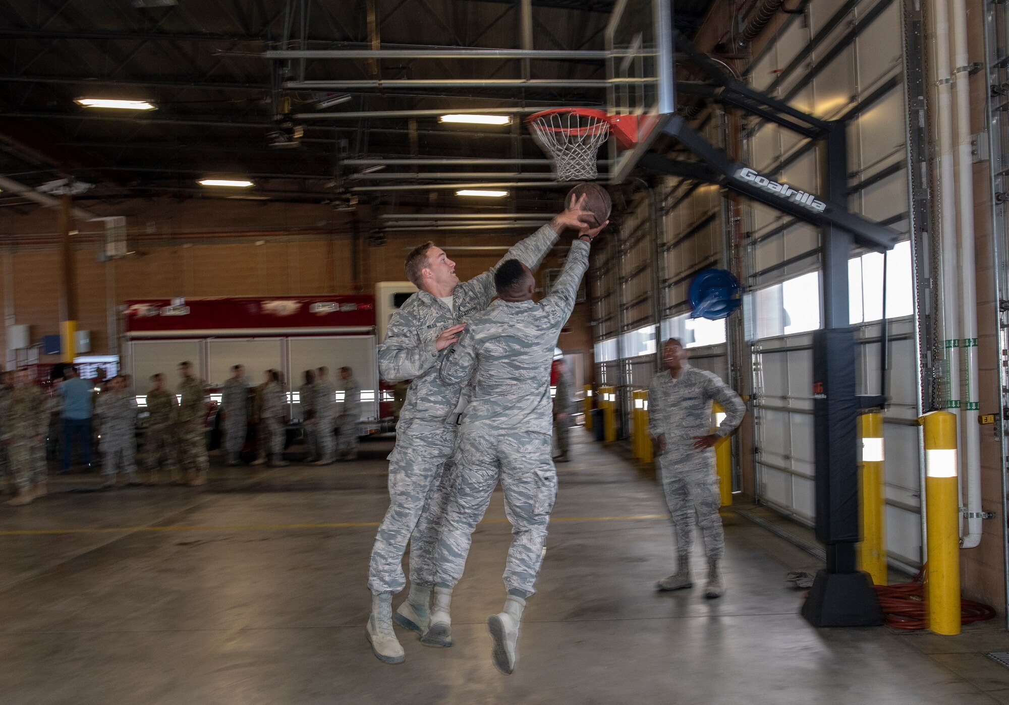 U.S. Air Force Airman Rex Miles and Airman 1st Class Cody Shelton, 60th Civil Engineer Squadron electrical system technicians, play basketball June 24, 2019, at Travis Air Force Base, California. The Airmen engaged in an impromptu basketball game prior to a squadron group photo. The Air Force Fitness Program’s goal is to motivate Airmen to participate in a year-round physical conditioning program that emphasizes total fitness, including proper aerobic conditioning, strength and flexibility training and healthy eating. Health benefits from an active lifestyle increases productivity, optimizes health and decreases absenteeism while maintaining a higher level of readiness. (U.S. Air Force photo by Heide Couch)