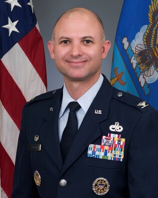 Col Sassen official photo with American and Air Force flags background