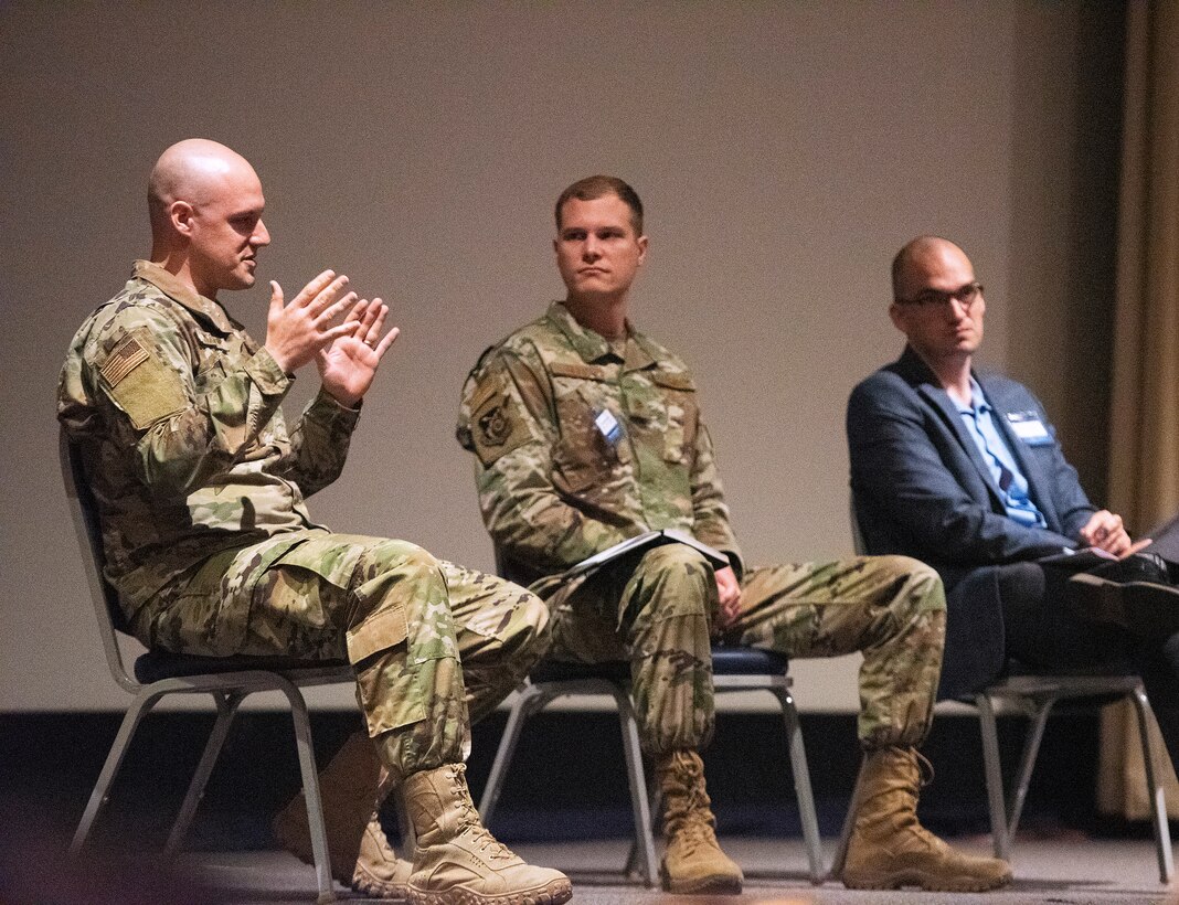 Maj. Zachary McCarty (left), Maj. Matthew Getts and Dr. Michael Tanner discuss a variety of topics during the Implementing Acquisition Transformation panel.(U.S. Air Force photo by R.J. Oriez)