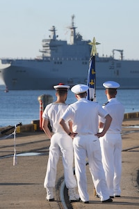 Members of the Marine Nationale (French Navy) watch Landing Helicopter Dock Tonnerre move toward the Columbus Terminal Port as part of a deployment stopover June 21, 2019, in Charleston, S.C. U.S. Navy Cmdr. Patrick Sutton, Naval Support Activity Charleston executive officer and 628th Mission Support Group deputy commander, spoke with leaders of LHD Tonnerre to ensure the crew received support during their stay in Charleston. Engagements such as this provide opportunities to strengthen partnerships between allies.