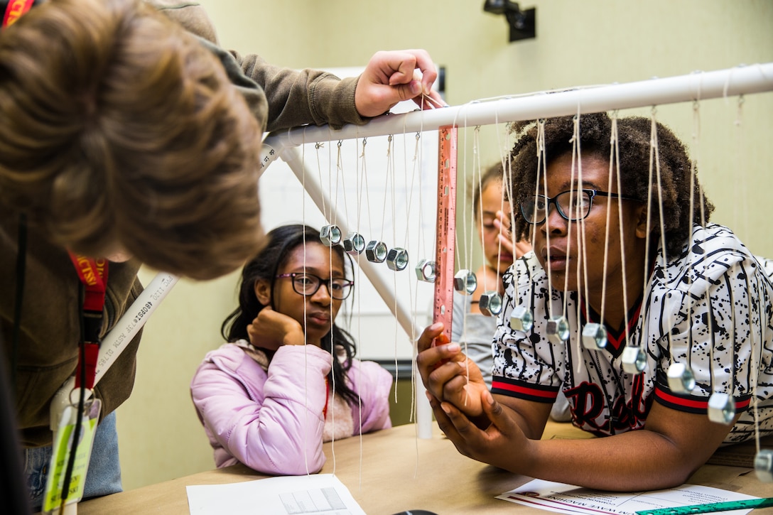 Junior high school-aged students from Marine Corps Base (MCB) Camp Pendleton and local area schools measure a pendulum during the Science, Technology, Engineering, and Math, 2019 Science Week at the Marine Corps Tactical Systems Support Activity Command Center, MCB Camp Pendleton, California, June 17, 2019. The 2019 Science Week is geared towards introducing students to new areas of technology outside of their every day school curriculum. (U.S. Marine Corps photo by Lance Cpl. Alison Dostie)