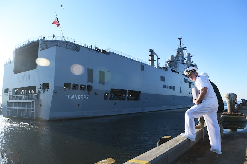 U.S. Navy Cmdr. Patrick Sutton, Naval Support Activity Charleston executive officer and 628th Mission Support Group deputy commander, waits for the Marine Nationale (French Navy) Landing Helicopter Dock Tonnerre to dock at the Columbus Terminal Port as part of a deployment stopover June 21, 2019, in Charleston, S.C. Sutton and Sailors of the 628th Logistics Readiness Squadron waterfront port operations spoke with leaders of LHD Tonnerre to ensure the crew received support during their stay in Charleston. Engagements such as this provide opportunities to strengthen partnerships between allies.