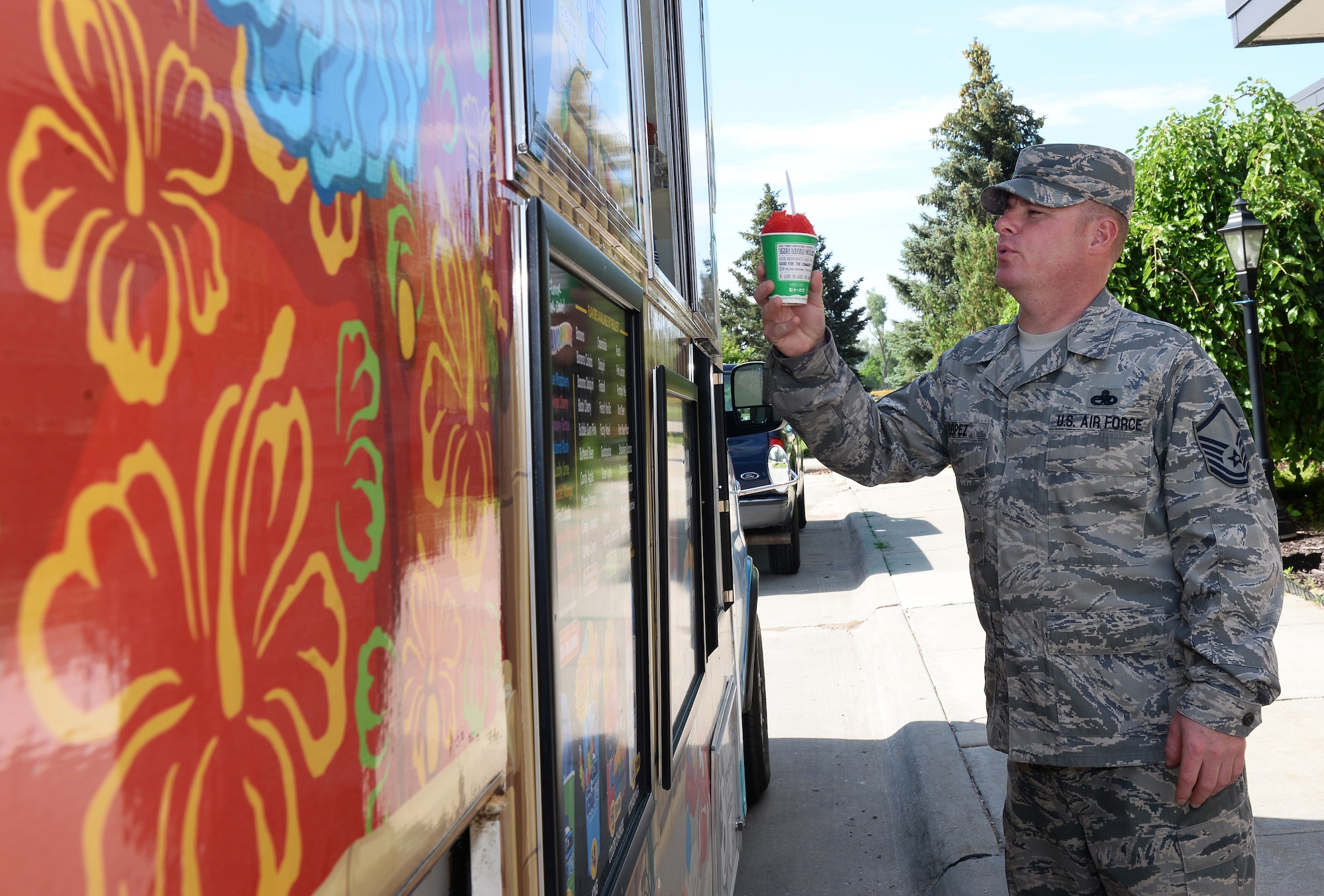 U.S. Air Force Master Sgt. Vicent Lopez, 55th Aircraft Maintenance Squadron, receives a tropical flavored shaved ice June 20, 2019, during a morale event at the Warhawk Community Center on Offutt Air Force Base, Nebraska. Shaved ice was served to team Offutt members at the Warhawk Community Center, 55th Wing Base Operations building and the Martin Bomber building. (U.S. Air Force photo by Charles J. Haymond)