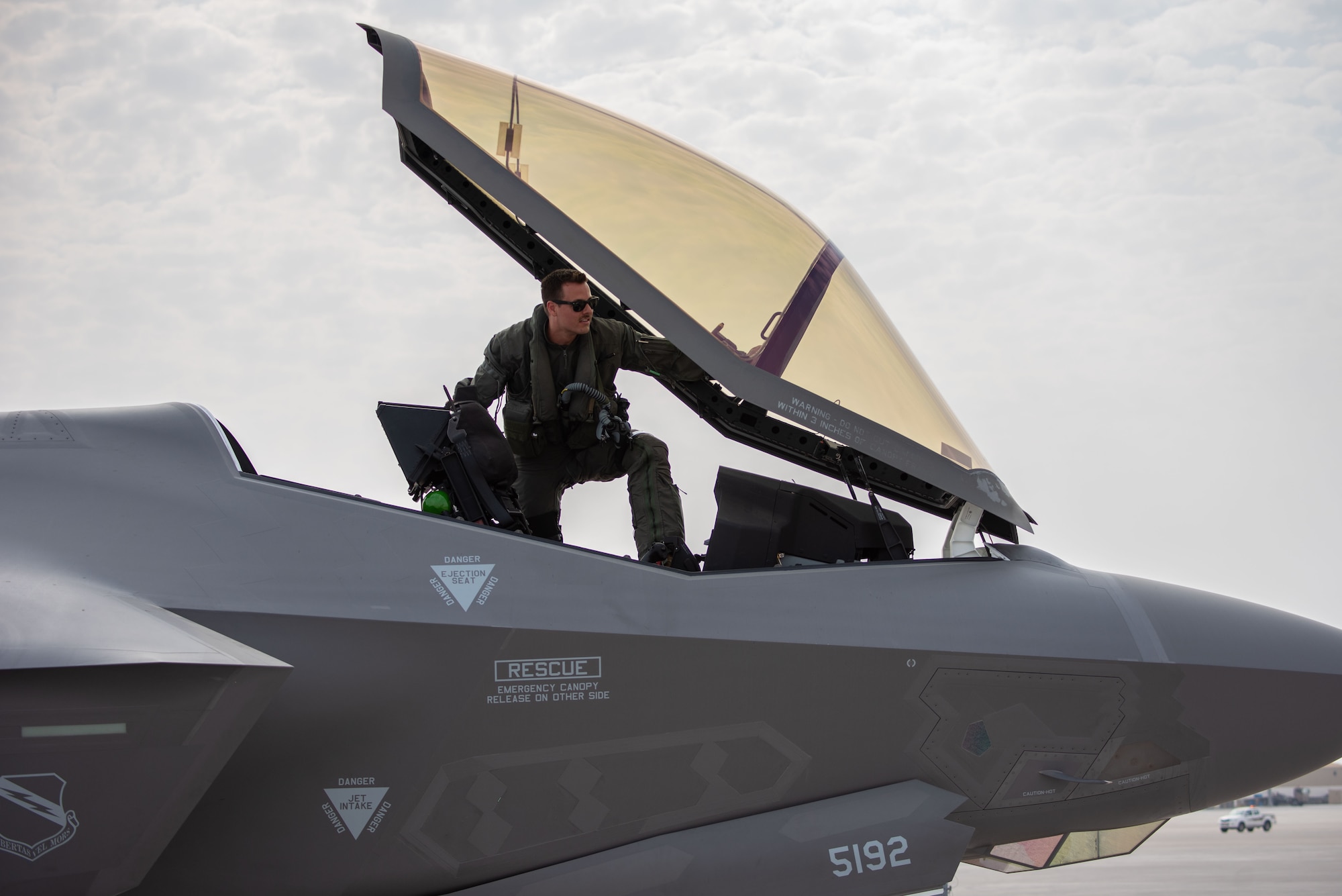 A photo of an F-35A pilot entering the cockpit.