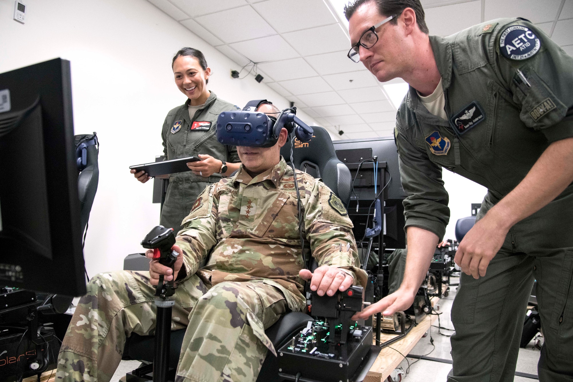 Gen. Jeffrey L. Harrigian (center), United States Air Forces Europe and United States Air Forces Africa commander, uses a virtual reality flight simulator during a visit to Detachment 24 at Joint Base San Antonio-Randolph, Texas, June 24, 2019.  PTN is an Air Education and Training Command program to explore and prototype a pilot training environment that integrates various technologies to produce pilots in a learning-focused manner. (U.S. Air Force photo by Sean M. Worrell)