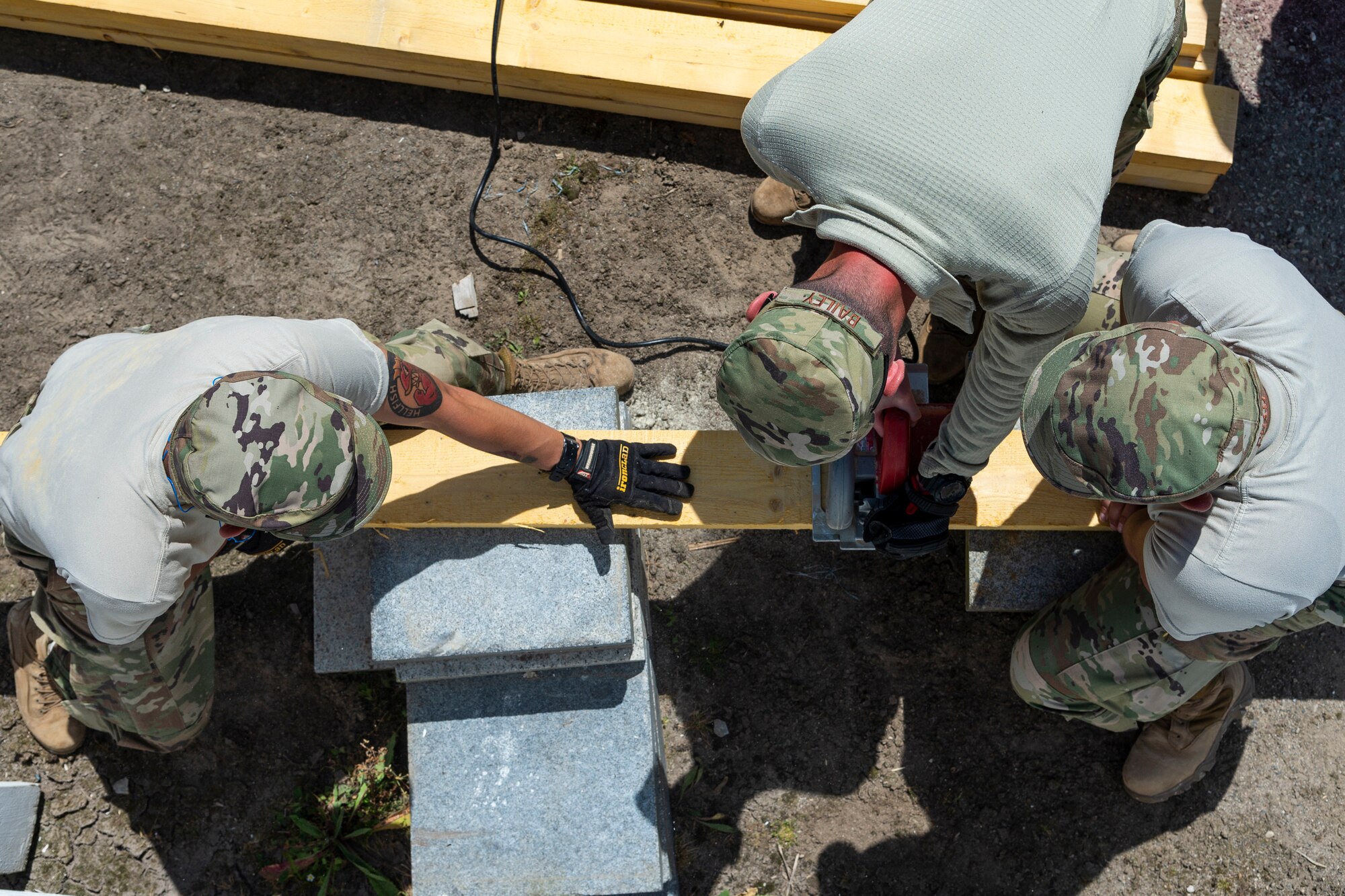 Airmen from the 23d Civil Engineer Squadron saw wood, June 1, 2019, in Sainte-Mère-Église, France. The engineers provided structural support for the Commemoration of D-Day 75 by repairing and building bridges that were used to access hard-to-reach areas of a parachute drop zone. As part of the commemoration, parachutists from across the Department of Defense performed the same jumps their predecessors did on D-Day. (U.S. Air Force photo by Airman 1st Class Hayden Legg)