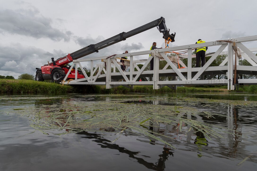 Contractors remove ties from a bridge, June 5, 2019, in Sainte-Mère-Église, France. Airmen from the 23d Civil Engineer Squadron provided structural support for the Commemoration of D-Day 75 by repairing and building bridges that were used to access hard-to-reach areas of a parachute drop zone. As part of the commemoration, parachutists from across the Department of Defense performed the same jumps their predecessors did on D-Day. (U.S. Air Force photo by Airman 1st Class Hayden Legg)