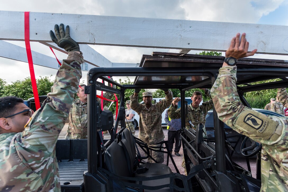 Airmen from the 23d Civil Engineer Squadron and members of the U.S. Army load a small bridge onto an all-terrain vehicle, June 5, 2019, in Sainte-Mère-Église, France. The engineers provided structural support for the Commemoration of D-Day 75 by repairing and building bridges that were used to access hard-to-reach areas of a parachute drop zone. As part of the commemoration, parachutists from across the Department of Defense performed the same jumps their predecessors did on D-Day. (U.S. Air Force photo by Airman 1st Class Hayden Legg)