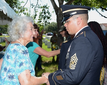Command Sgt. Maj. Gilberto Colon, 187th Medical Battalion, greets Rita Van Autreve during a ceremony honoring retired Sgt. Maj. of the Army Leon Van Autreve at a June 21 ceremony at the Fort Sam Houston National Cemetery.