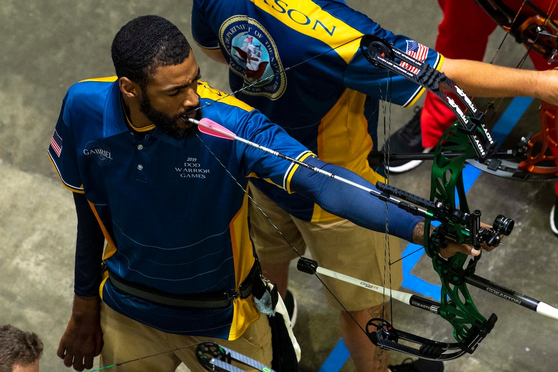 A sailor aims an arrow at a target.