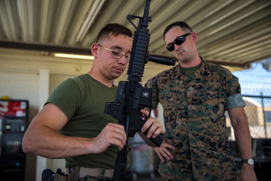 U.S. Marine Corps Lance Cpl. Tyler Huckleberry and U.S. Navy sailor HM2 David Manley, with Headquarters & Headquarters Squadron Marine Corps Air Station (MCAS) Yuma, conduct weapons training in order to qualify for the Enlisted Fleet Marine Force Warfare Specialist device on MCAS Yuma, June 11, 2019. In order to be awarded the device a sailor must complete the Fleet Marine Force Qualification Training in order to familiarize themselves with the Marine Corps. (U.S. Marine Corps photo by Lance Cpl. John Hall)