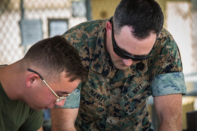 U.S. Marine Corps Lance Cpl. Tyler Huckleberry and U.S. Navy sailor HM2 David Manley, with Headquarters & Headquarters Squadron Marine Corps Air Station (MCAS) Yuma, conduct weapons training in order to qualify for the Enlisted Fleet Marine Force Warfare Specialist device on MCAS Yuma, June 11, 2019. In order to be awarded the device a sailor must complete the Fleet Marine Force Qualification Training in order to familiarize themselves with the Marine Corps. (U.S. Marine Corps photo by Sgt. Isaac D. Martinez)
