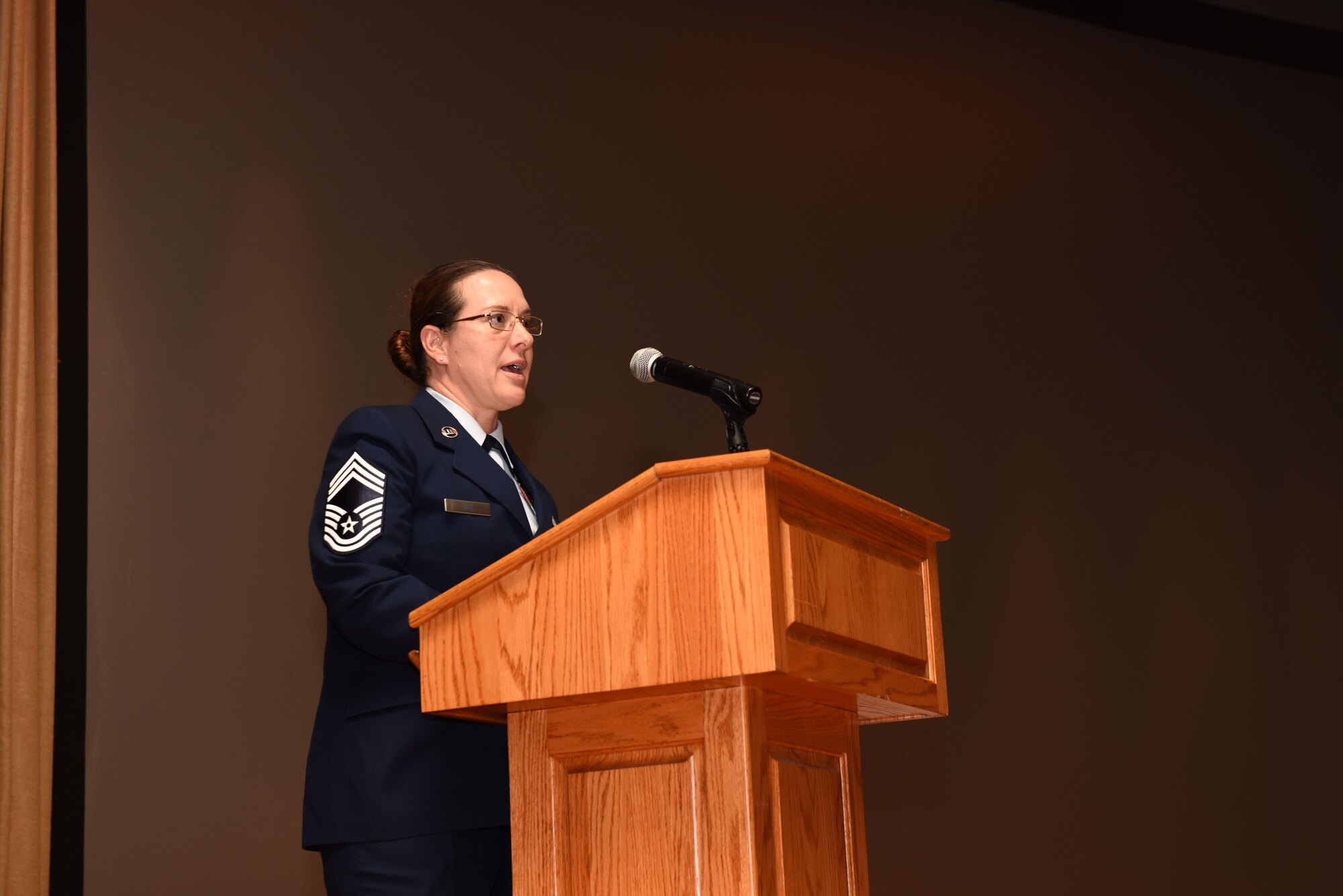 U.S. Air Force Chief Master Sgt. Shae Gee, 17th Mission Support Group superintendent, speaks to attendees about her personal experiences pursing education at the Community College of the Air Force Commencement Ceremony at the base theater on Goodfellow Air Force Base, June 21, 2019. Gee joined the Air Force in 1994 and holds two CCAF degrees as well as a Bachelor of Science Degree in Organizational Management and a Master of Business Administration Degree in organizational leadership. (U.S. Air Force photo by Senior Airman Seraiah Wolf/Released)